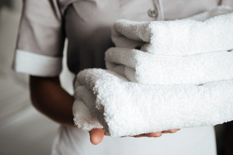 close-up-of-a-young-maid-holding-folded-towels_WEB