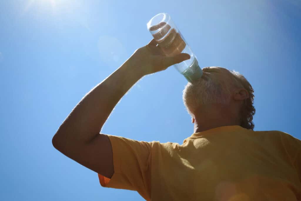 Old Man Drinking Water in Summertime