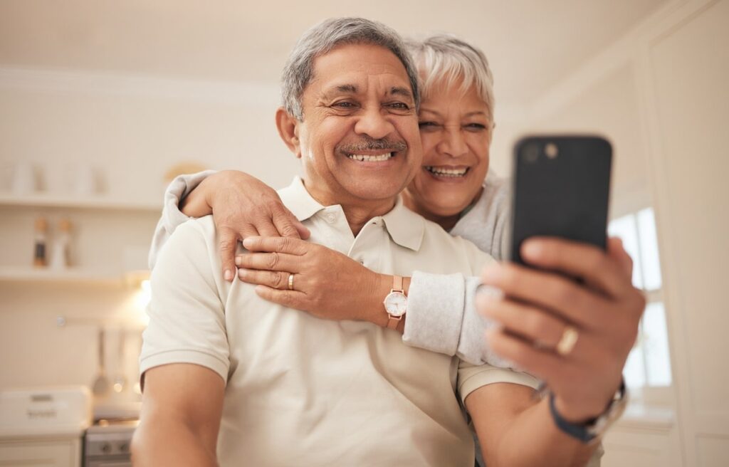 Couple of older adults making a video call on their smartphone.