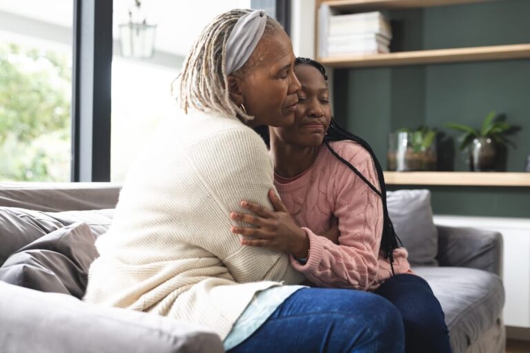 Older woman and daughter hugging.