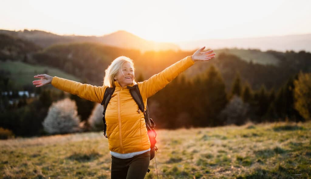 Older woman joyful on an open field.