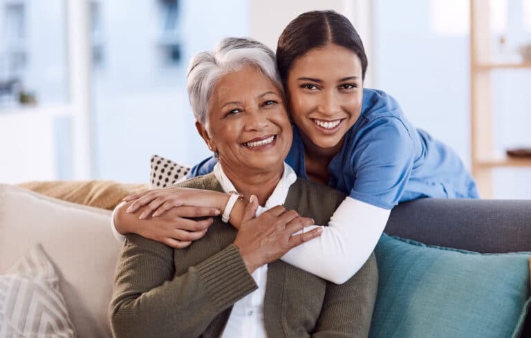 Caregiver hugging an older woman.