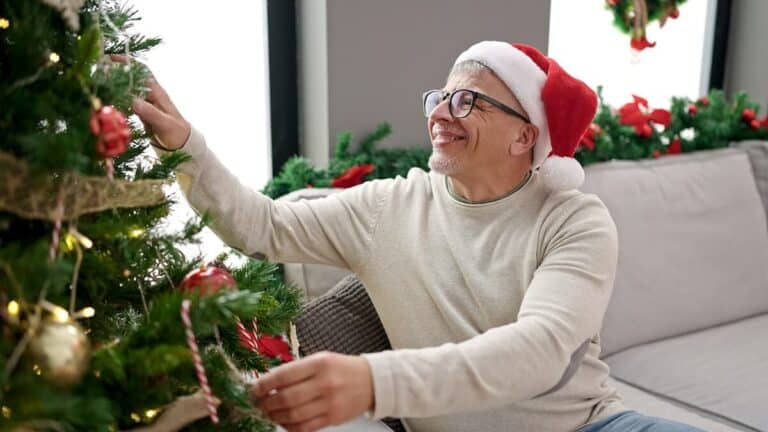 Older man decorating his Christmas tree