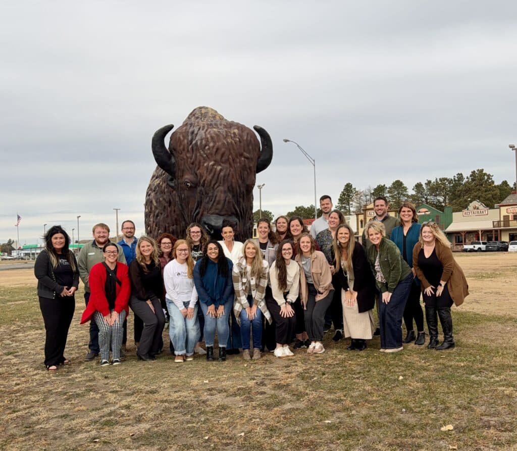 team photo outside Al's Oasis in Oacoma, South Dakota
