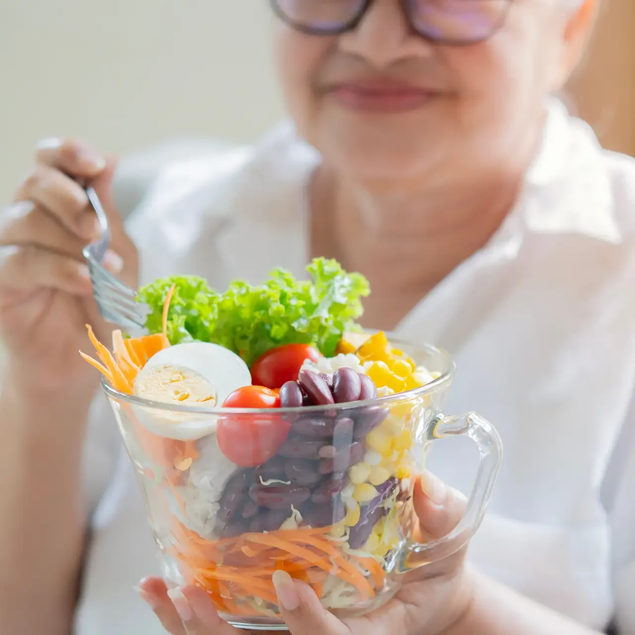 Senior woman eating salad